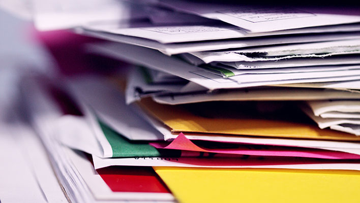 Stacks of utility documents that could be turned paperless with the help of ARCOS's utility solutions
