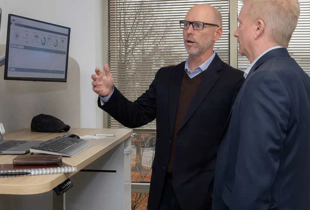 Arcos employees reviewing the report on monitor