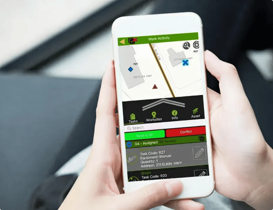 A person is holding a smartphone displaying a work activity app with tasks and locations.