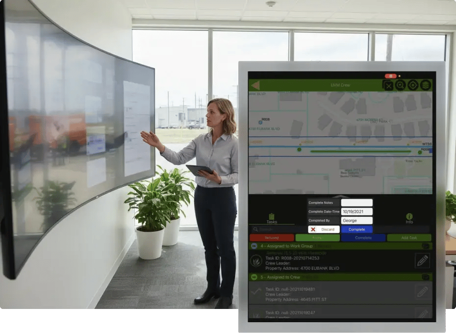 Woman presenting data on interactive screen with digital map overlay.