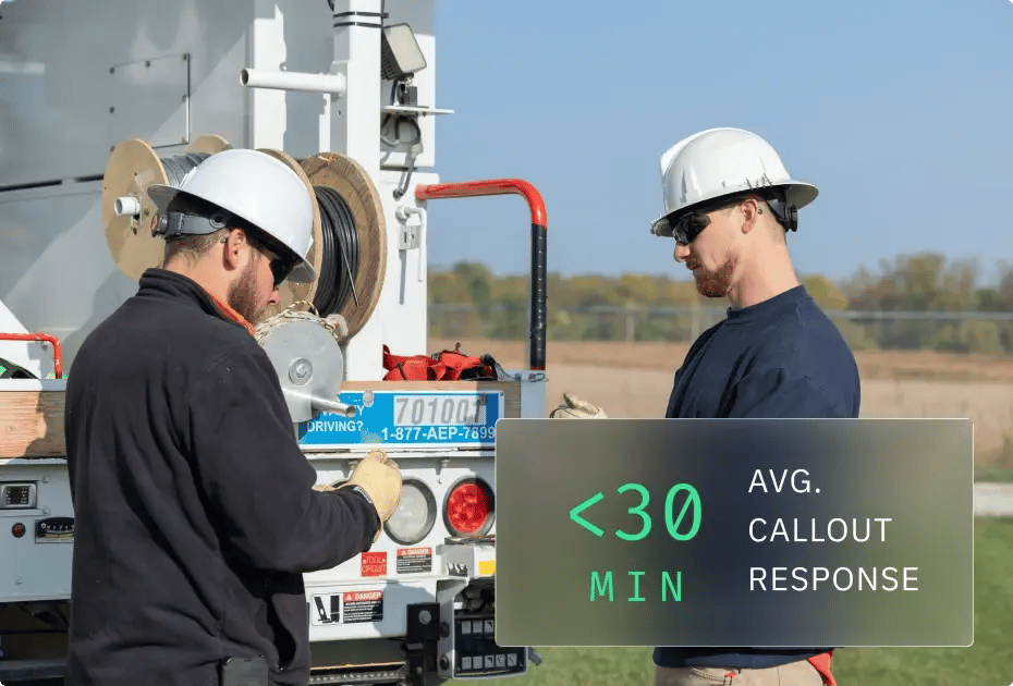 Two workers in safety gear beside utility truck with avg. callout response time of <30 min.