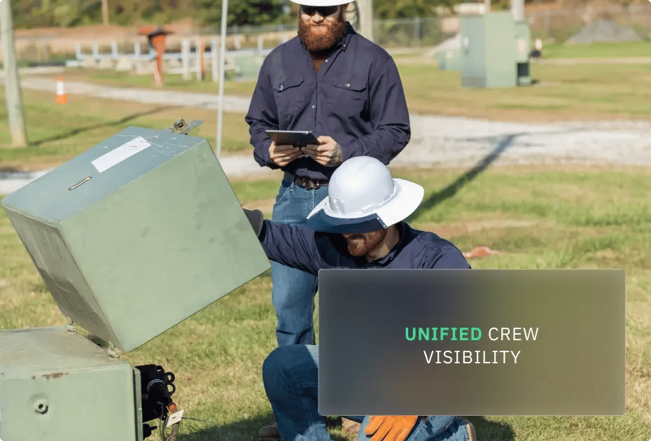 Two workers wearing hard hats inspecting electrical equipment outdoors.
