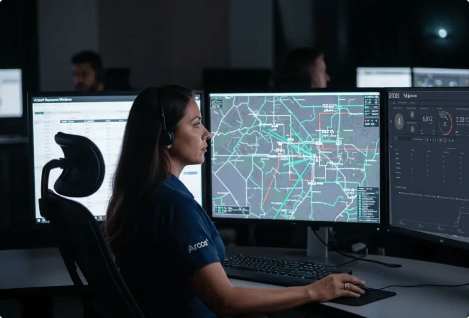 Operator monitoring multiple screens with maps and data.