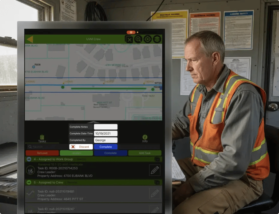 Man in safety vest using digital map interface with tasks and notes.