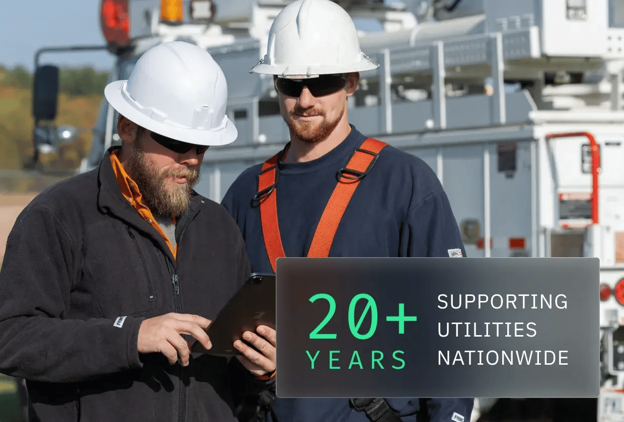 Two workers in hard hats examine a tablet, with a utility truck in the background, emphasizing 20+ years of service to utilities nationwide.