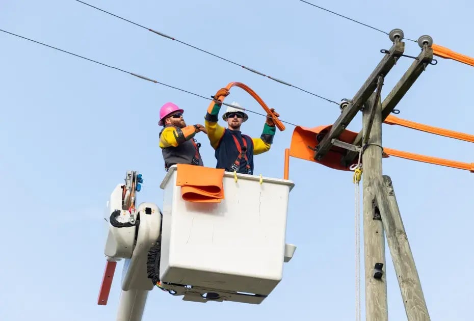 Utility workers installing power lines on pole