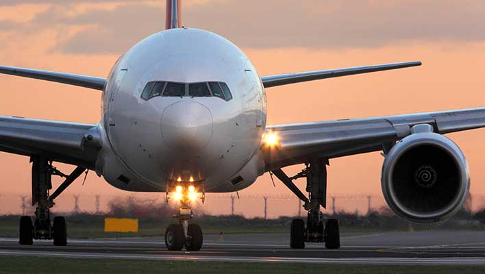 The front of a plane getting ready to take off at sunset