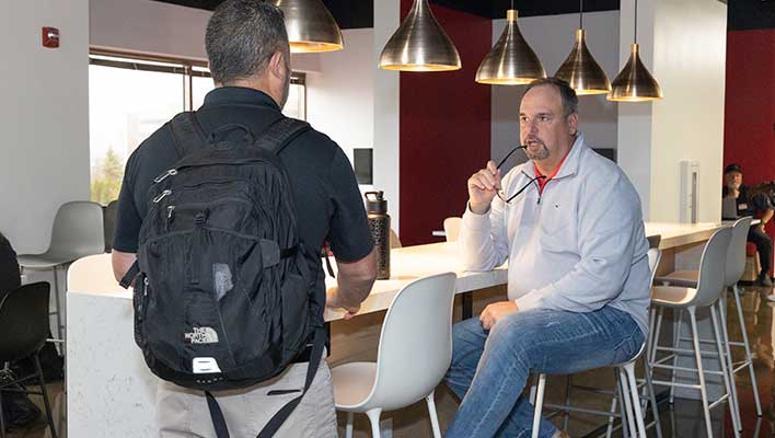 Two ARCOS employees discussing resource management in a lounge