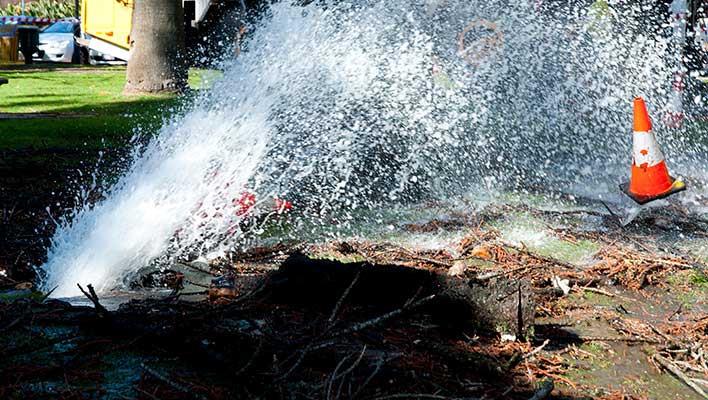 A water main leak shooting water up and out onto the street