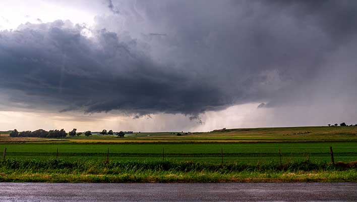 View of rain clouds over green, low hills