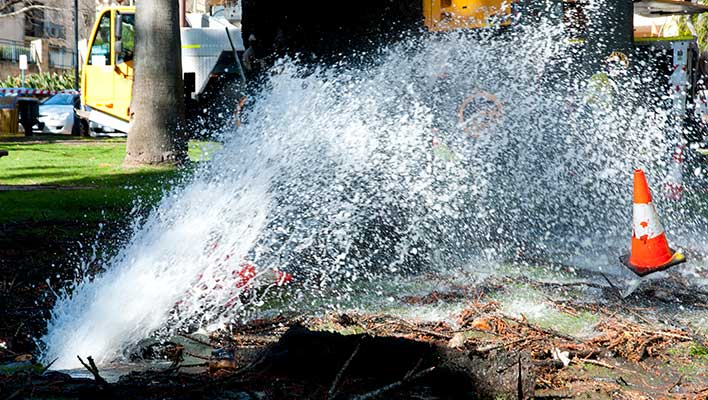 A water main leak shooting water up and out onto the street