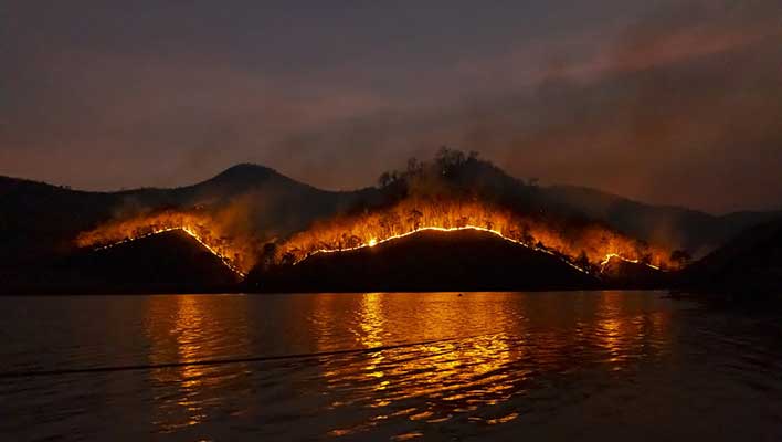 wildfire burning on the hillside at dusk