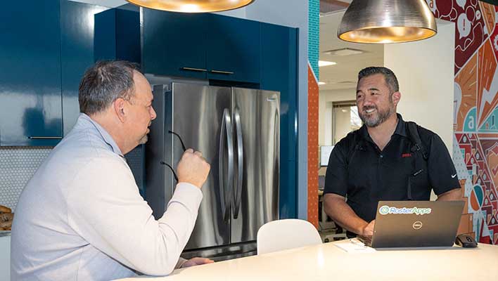 Two ARCOS employees chatting in ARCOS HQ's kitchen area