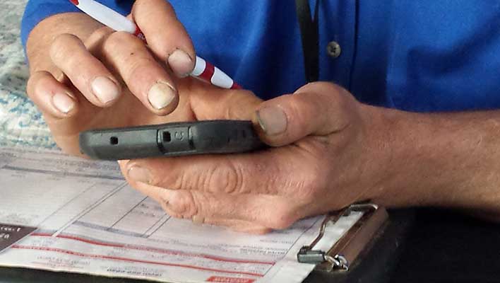 close view of dirty hands holding a cell phone