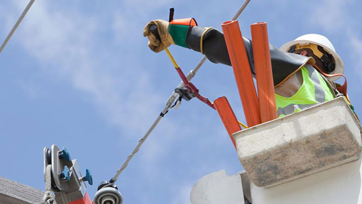 A utility worker getting ready to cut a power line