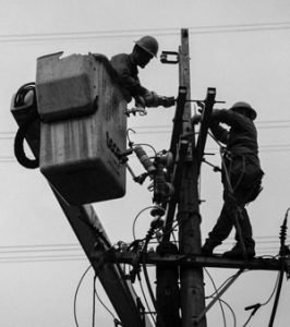Two linemen working on a pole