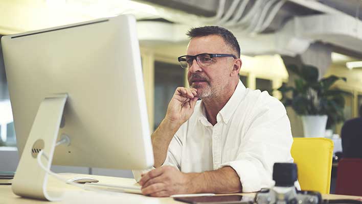 Middle aged business man looking at a computer screen