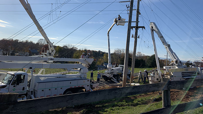 Utiltiy workers in trucks working on power lines