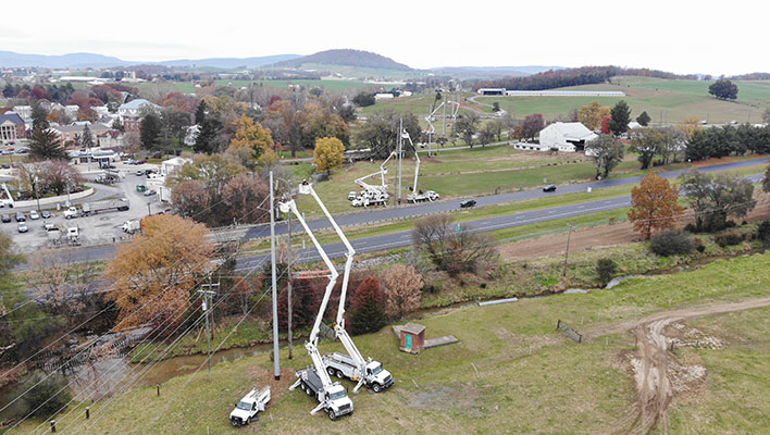 An aerial view of utility trucks working on power lines