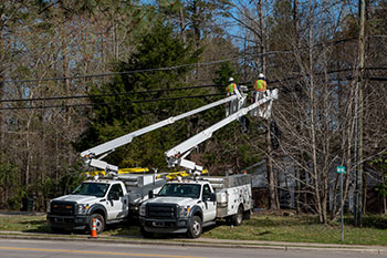Two bucket trucks working on a power line