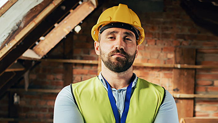 A construction worker standing in a brick room