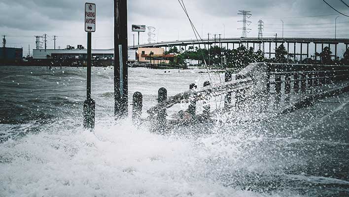 Flood water crashing over a bridge