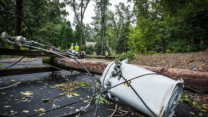 Close up view of a transmission line which has fallen across the road, with an emphasis on the capacitor