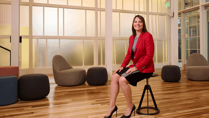 Bonnie Titone sitting on a stool, excited to join the ARCOS Board of Directors