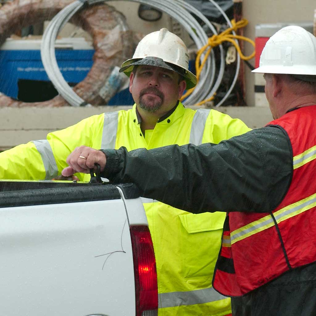 Crew managers discussing in front of electrical repair tools