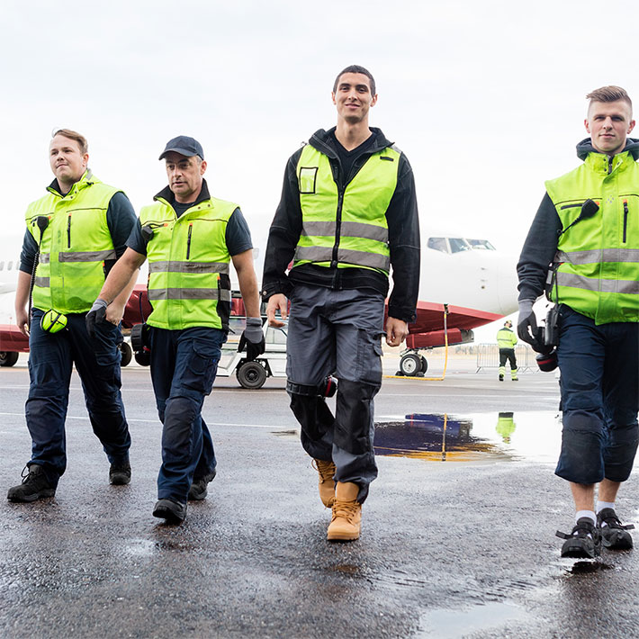 Ground Crew workers walking toward the viewer on the tarmac