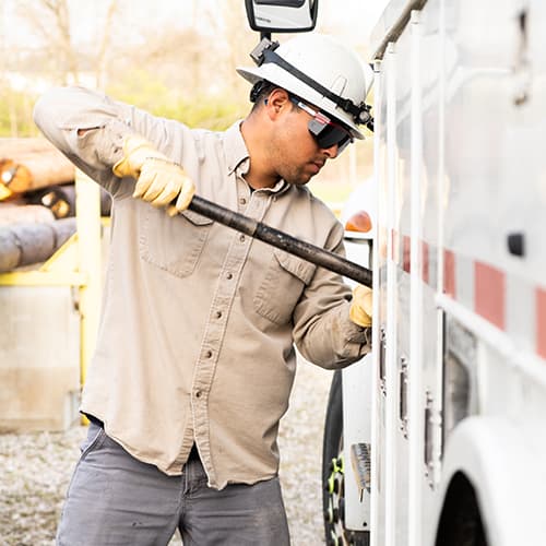 A utility crewman tightening a bolt with a large wrench