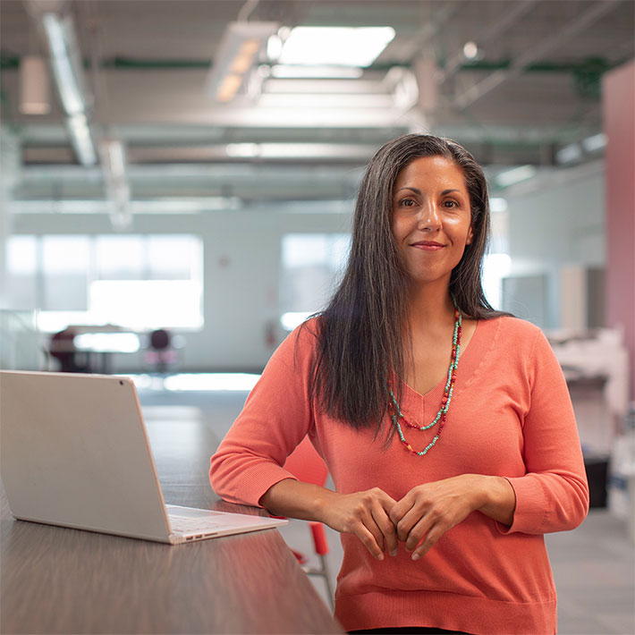 Businesswoman looking at the camera while leaning against a table