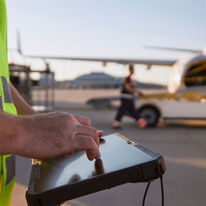 Closeup of a utility worker on an airport runway using a tablet