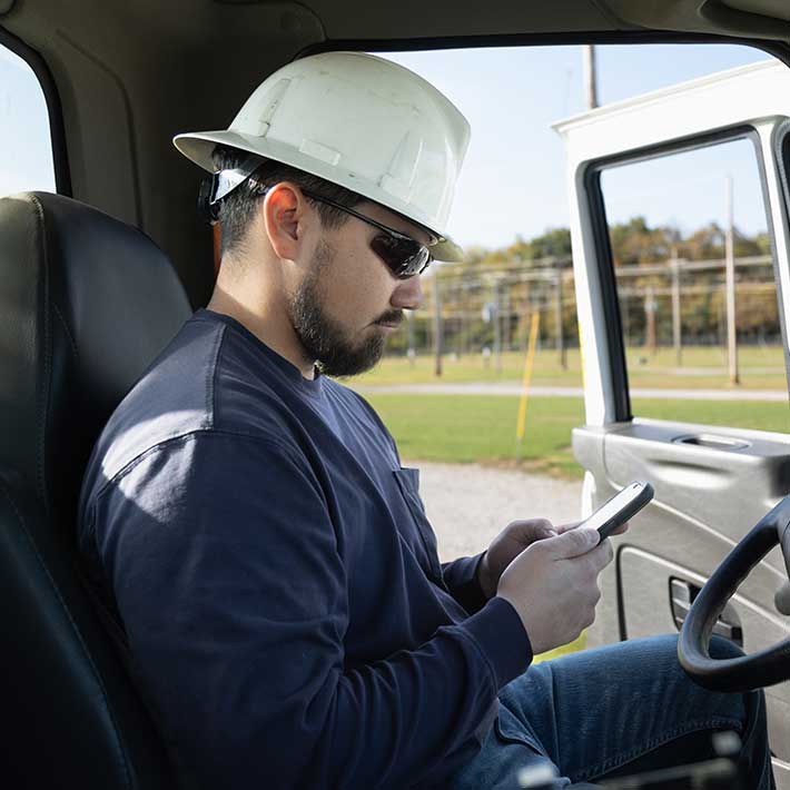 A utility worker using ARCOS's Automated Callouts App while sitting in his car