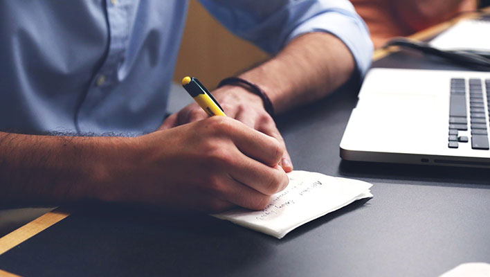 A person jotting down notes on a piece of paper