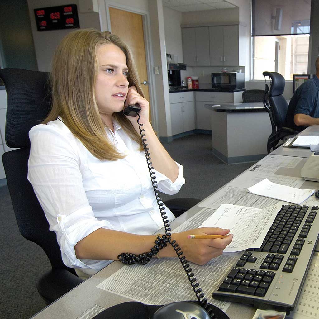 A receptionist sitting at her desk taking a call