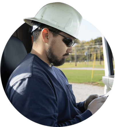 A gas utility worker using ARCOS's Automated Callouts App while sitting in his car