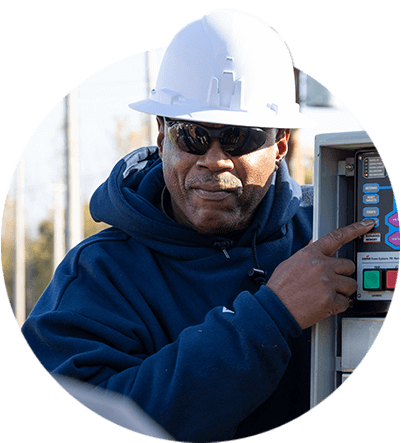 A utility worker pointing towards a power console