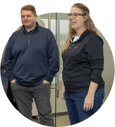 Two ARCOs employees standing together, laughing in an office