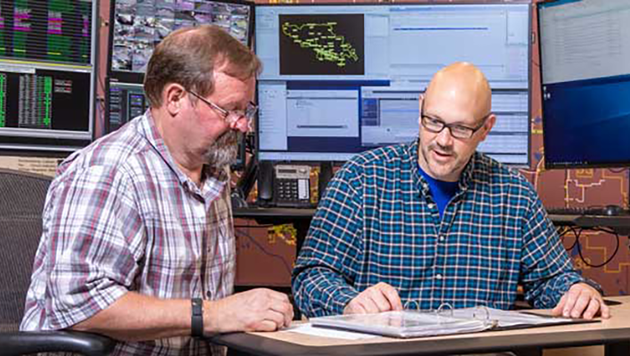 Two men looking at a shared document on a desk