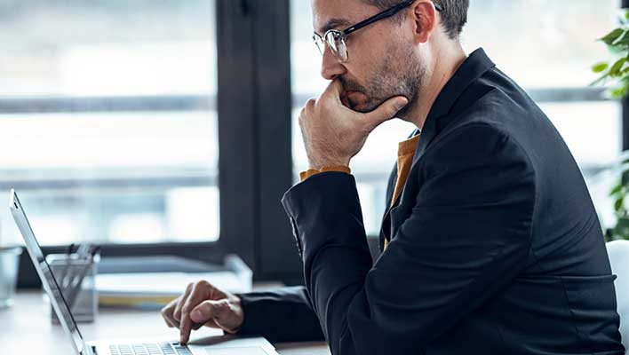 Side view of an office worker using a laptop.