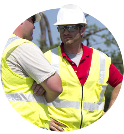 Two workers in hard hats talking with each other